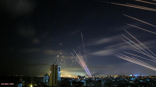 TOPSHOT - In the background the Israeli Iron Dome missile defence system (L) intercepts rockets (R) fired by the Hamas movement towards southern Israel from Beit Lahia in the northern Gaza Strip, and on foreground tens of other intercepts rockets (RR) fired by the Hamas while the Iron Dome is busy with the first rockets, as seen in the sky above the Gaza Strip overnight on May 16, 2021. - Israel pummelled the Gaza Strip with air strikes, killing 10 members of an extended family and demolishing a building housing international media outlets, as Palestinian militants fired back barrages of rockets. (Photo by ANAS BABA / AFP) (Photo by ANAS BABA/AFP via Getty Images)